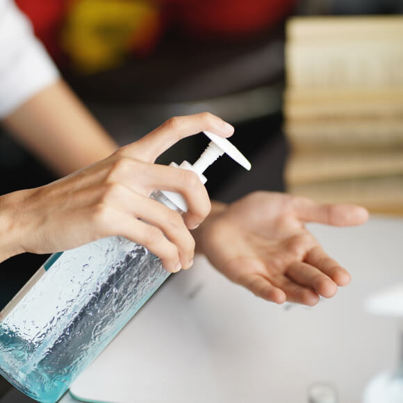 Close-up on a person's hands using sanitizer.